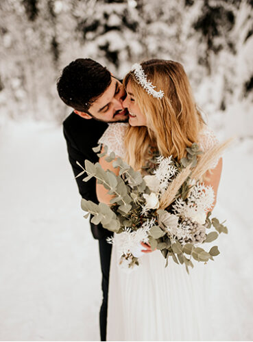 Braut und Bräutigam im Schnee mit Boho Brautstrauß im Winterlook